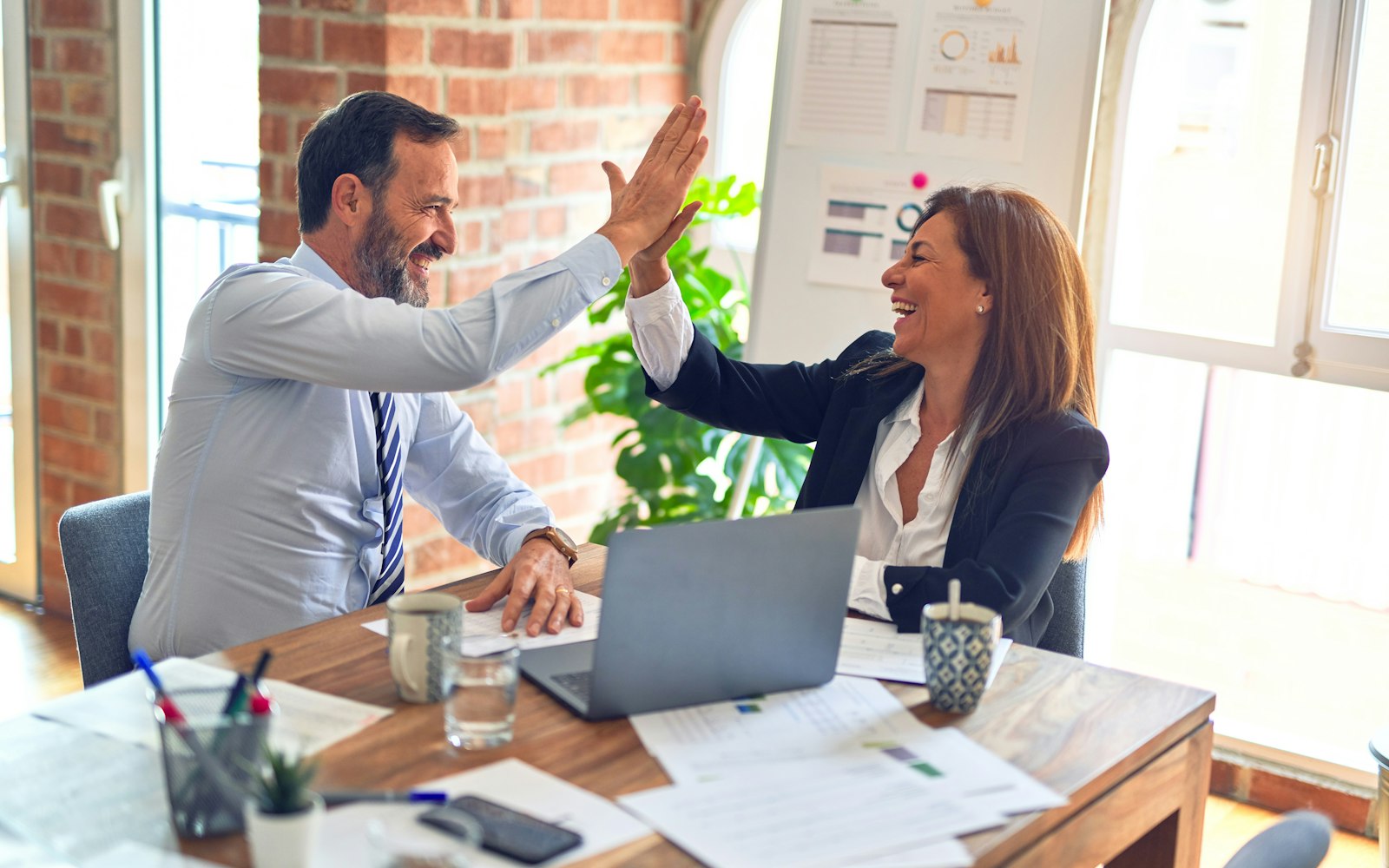 Two colleagues celebrating at a desk